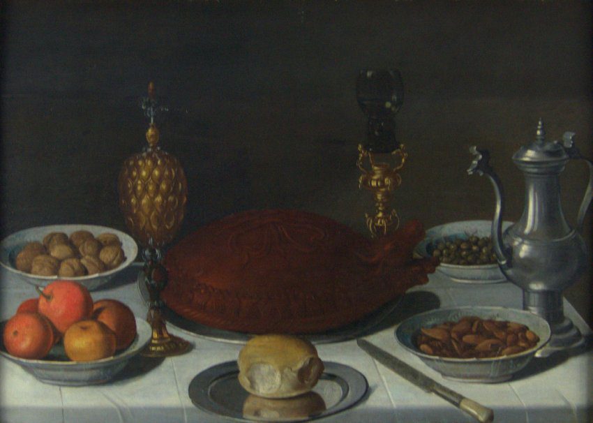 Attributed to Pieter Claesz (Dutch, 1597 or 98-1660), A Table Still Life, 1600s, oil on panel. Gift of Mr. Nathan Joseph Leigh, 1960.1.


While some Dutch and Flemish still life table scenes show a loose assortment of fruit, flowers, and luxury goods, this orderly composition illustrates the “banquet” still life type favored by some Haarlem artists such as Pieter Claesz, Willem Claesz, and Floris van Dyck. A decorative pastry meat pie forms the centerpiece, while expensive fruits, nuts, and other items arranged in bowls form a balanced composition. In the foreground, a roll on a metal plate rests just beyond the edge of the table, while a knife likewise extends into the viewer’s space, inviting us to imagine ourselves as participants in the feast.